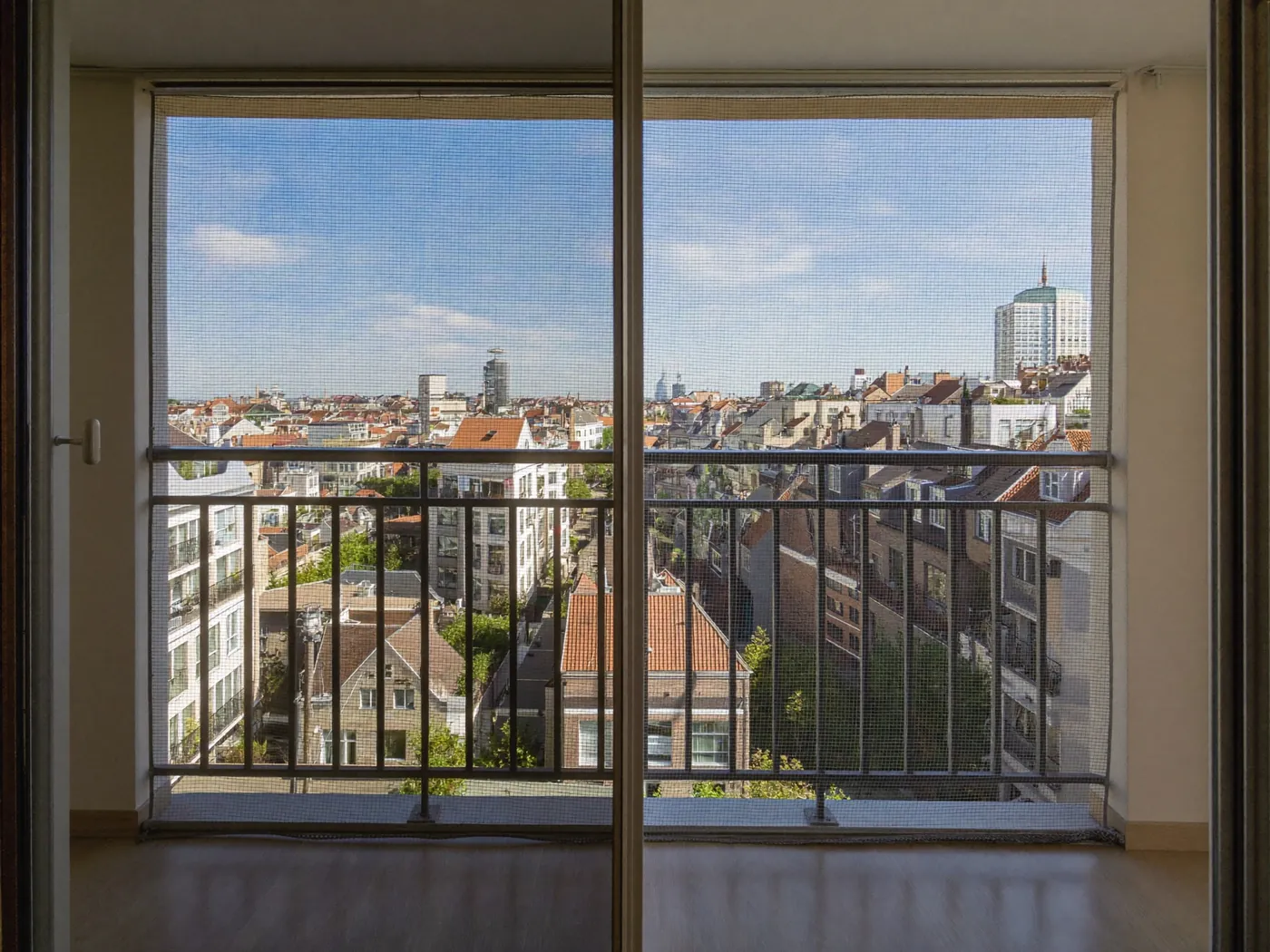 Balkon met nette duivenwering, uitzicht over de stad